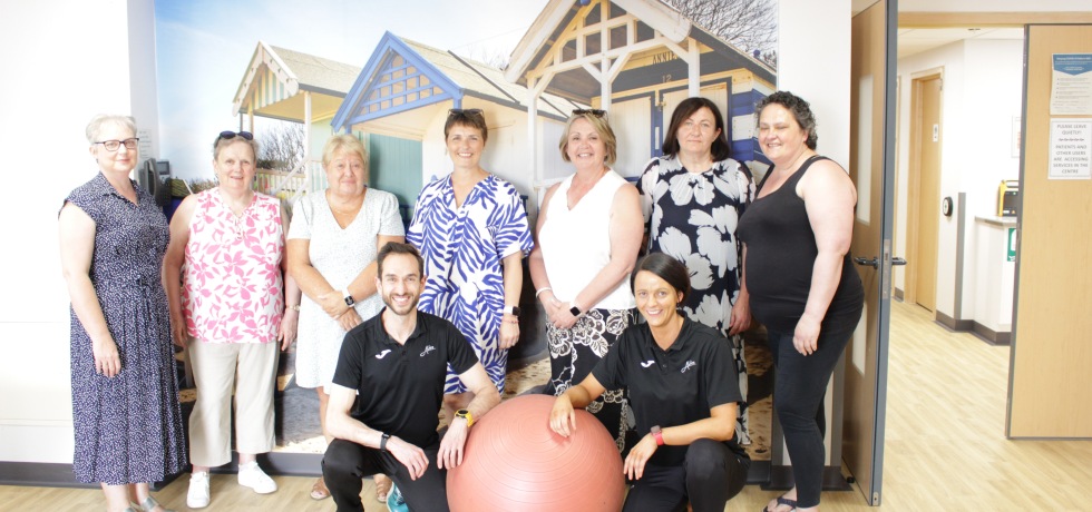 Members of the QEH physical activity programme for patients affected by cancer posing with Alive West Norfolk Cancer Rehabilitation Exercise Professionals Jose and Carolyn.