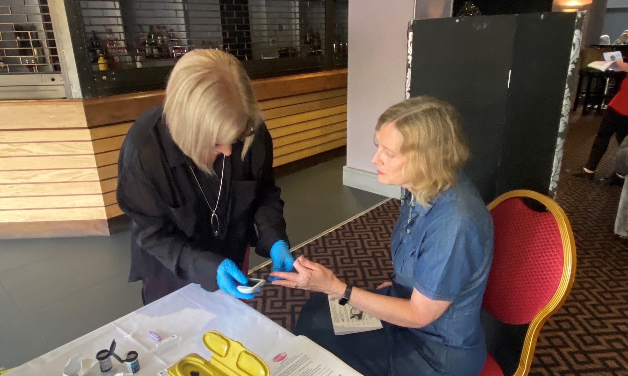 A person receiving a free finger prick blood glucose test