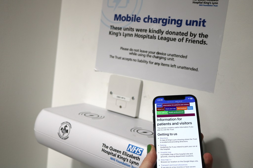 A picture of someone about to place their phone on the mobile charging unit.