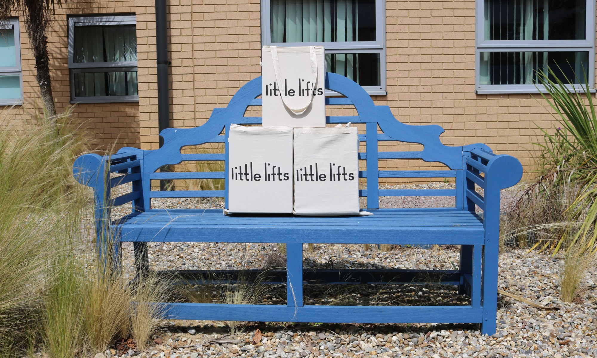 A picture of the Little Lift boxes sat on a blue bench.