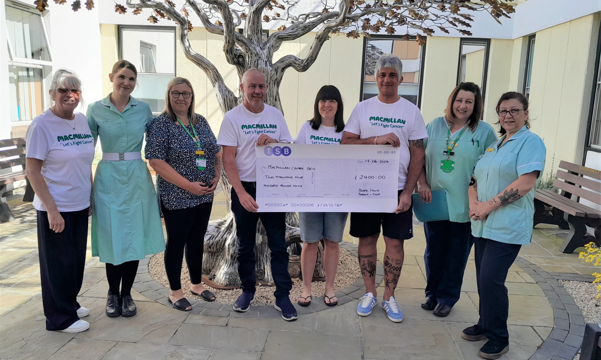 Duane and Laura Gowen and Debbie and Scott Knight holding up a giant cheque with Macmillan Unit Nurses