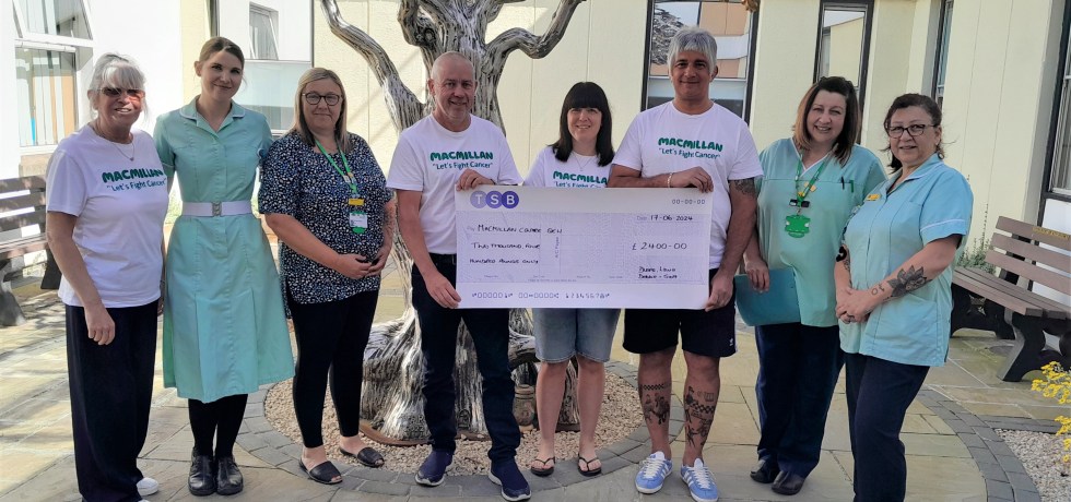 Duane and Laura Gowen and Debbie and Scott Knight holding up a giant cheque with Macmillan Unit Nurses