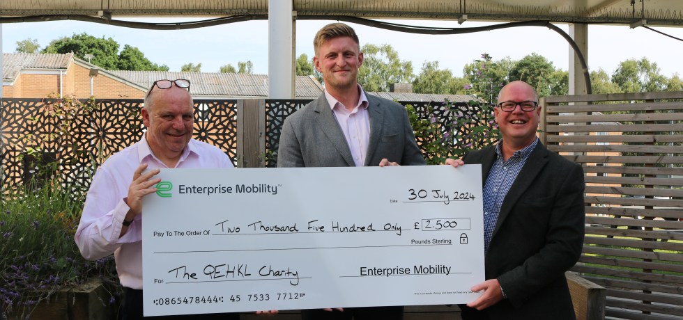 A picture of Alex and Warren from Enterprise presenting a giant cheque to Financial Controller, James Knott