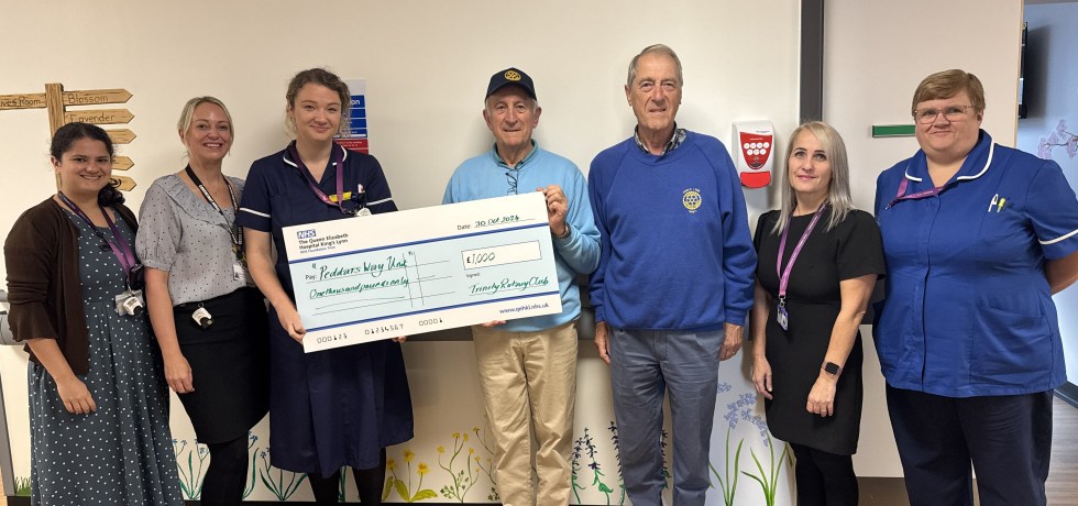 A picture of the Trinity Rotary Club handing a giant novelty cheque worth £1,000 to the palliative for their end of life unit