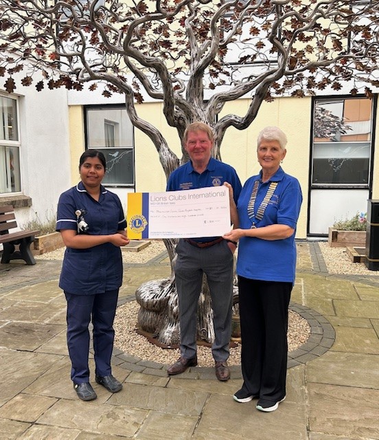 Jane and Paul handing a giant cheque to chief nurse
