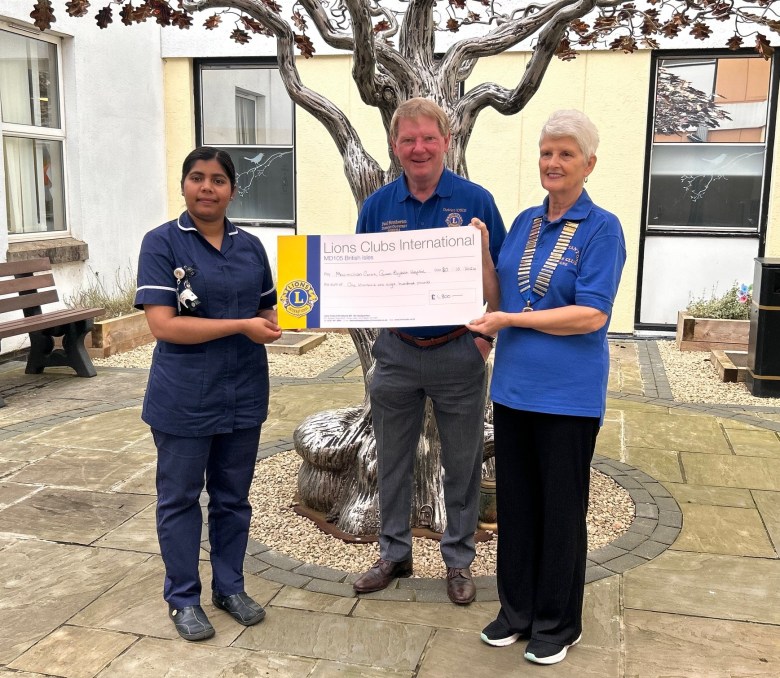 Jane and Paul handing a giant cheque to chief nurse