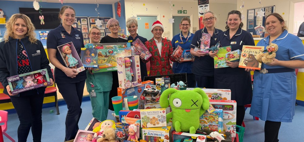 People standing around the donated toys posing for a photo.