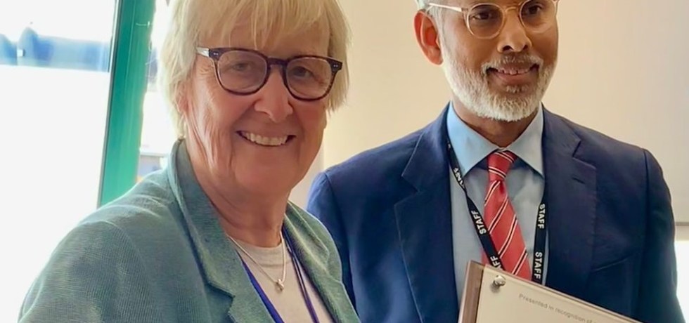 Two people posing with a certificate.