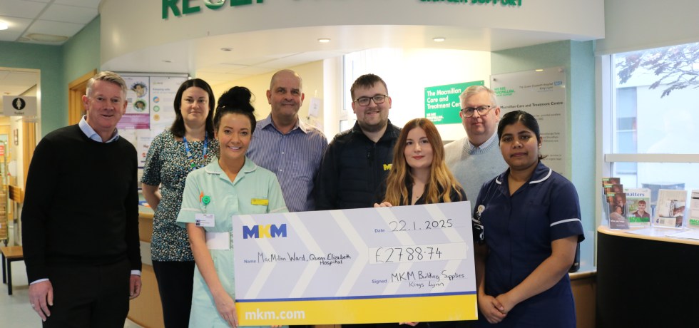 A picture of the MKM group presenting a giant novelty cheque to nurses in the QEH's Macmillan Unit.