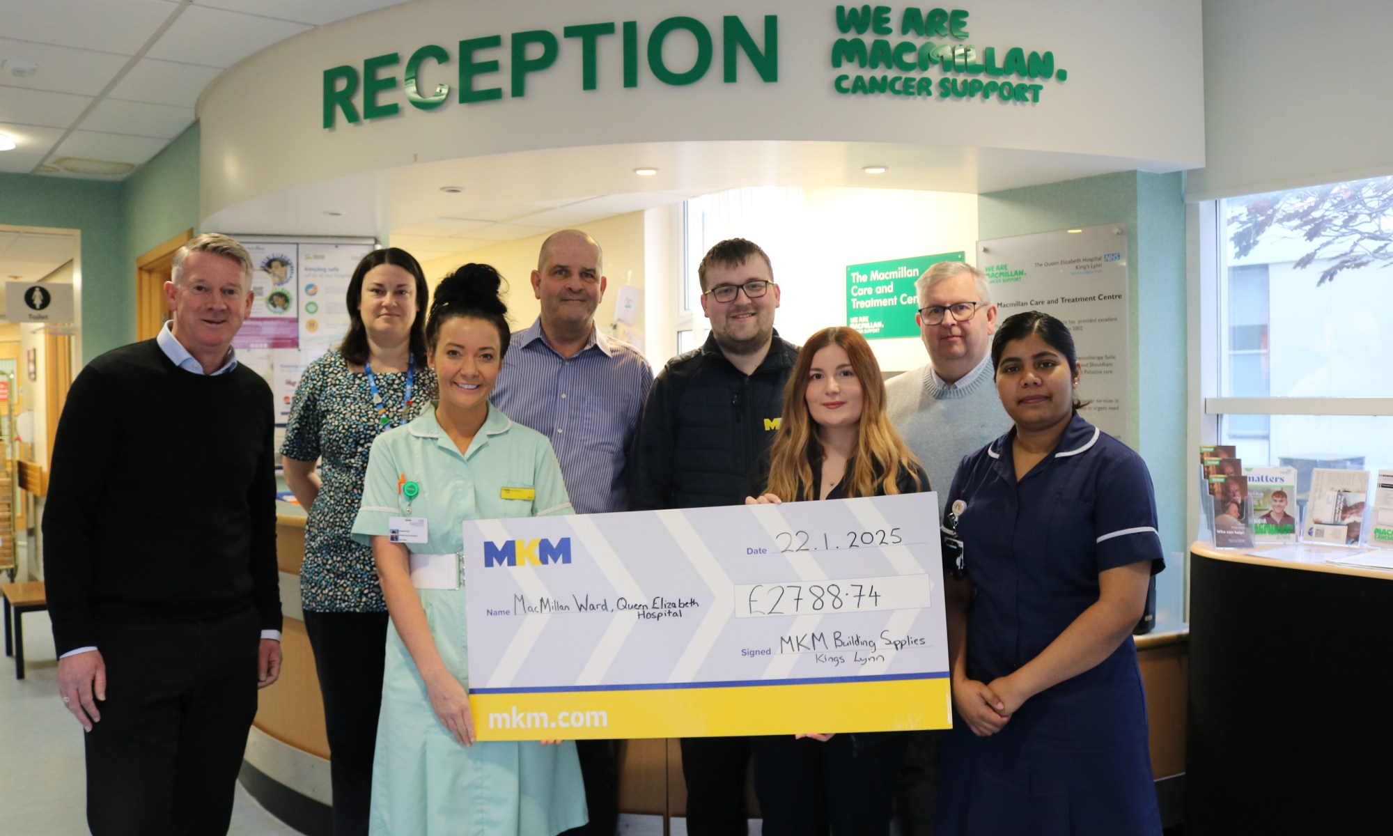 A picture of the MKM group presenting a giant novelty cheque to nurses in the QEH's Macmillan Unit.