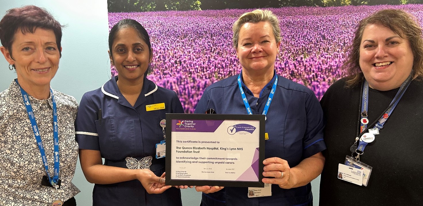 Four people standing holding a framed certificate.