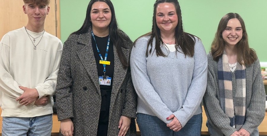 Four people standing in a line.