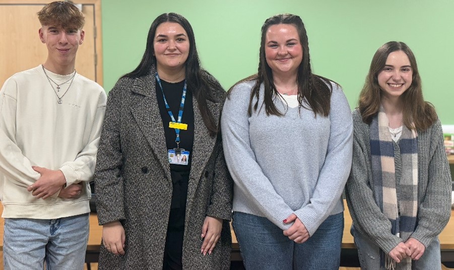 Four people standing in a line.