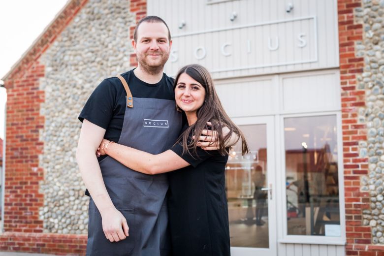 A picture of Socius owners - Natalie and Dan Lawrence in front of the restaurant