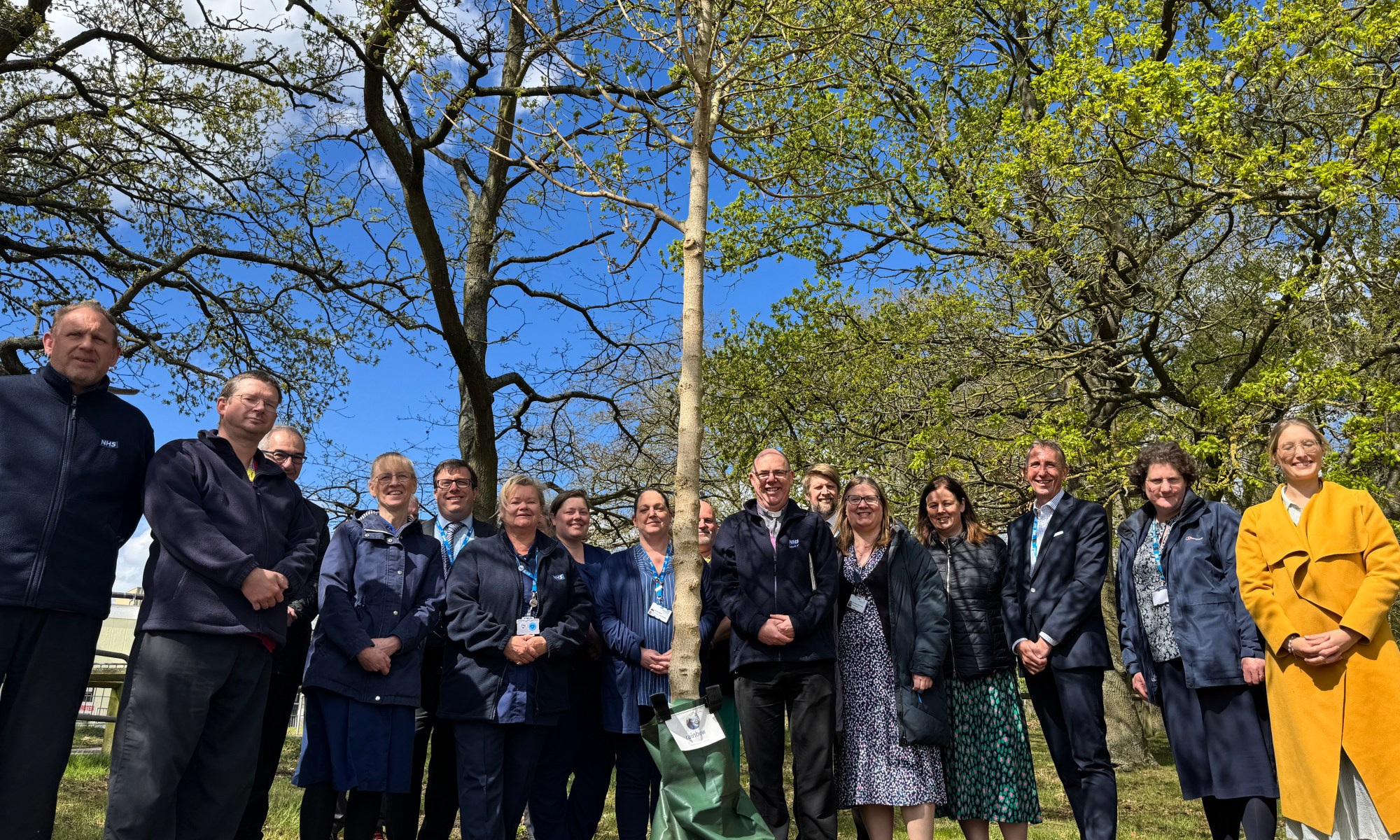 Group of people standing outside in front of a tree
