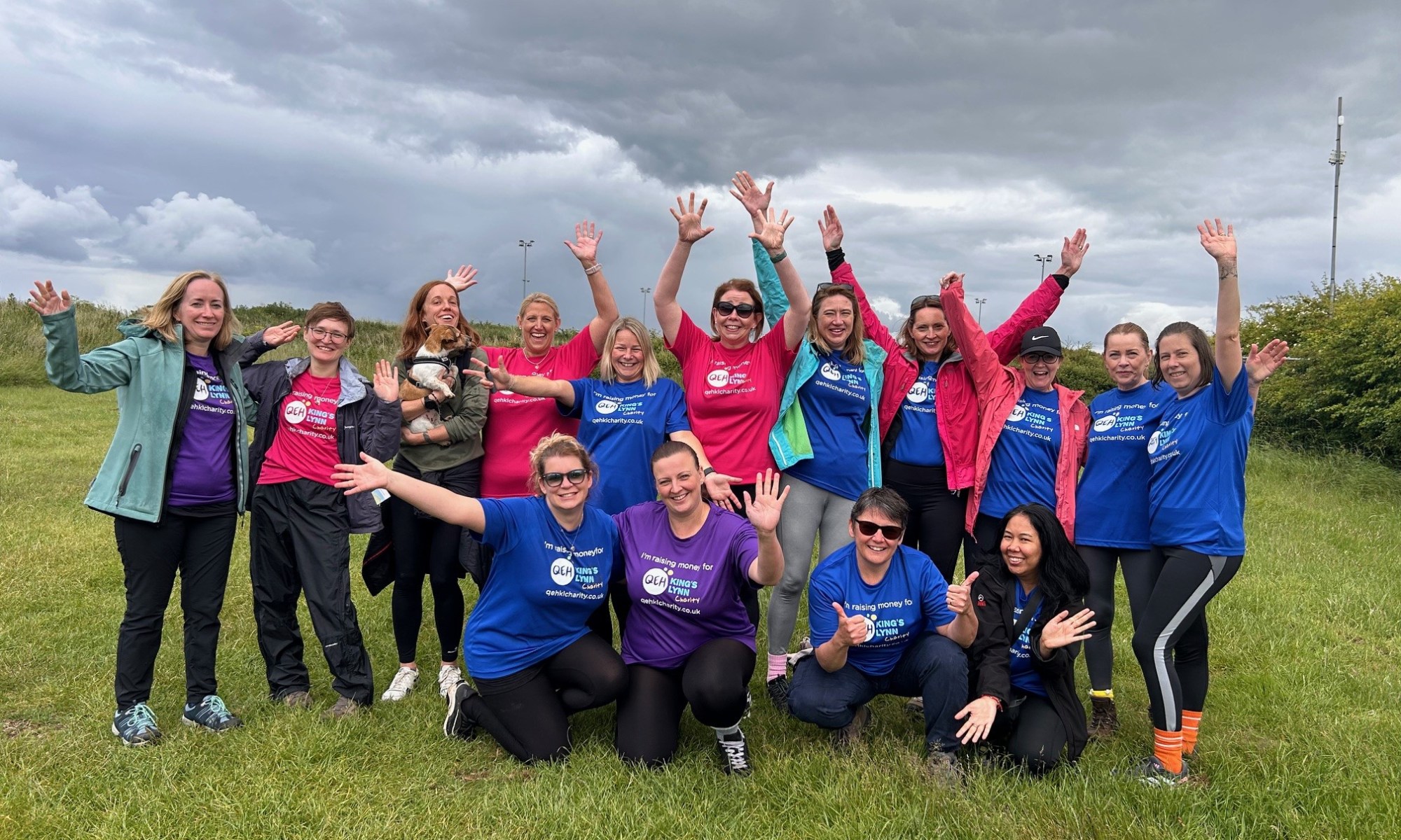 A photo of the QEHKL Walkers wearing "I'm raising money for the QEHKL Charity" t-shirts, smiling and waving their hands in the air