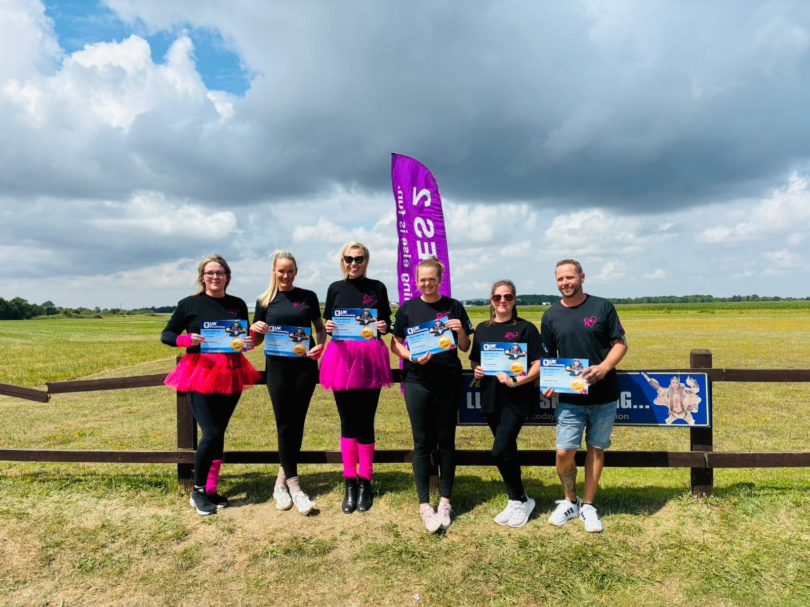 Melanie Batchelor, Nick Marsh, Sophie Beales, Lynne Dean, Rebecca Bowman and Leanne Brooks holding their completed skydiving certificated in Norwich airfield