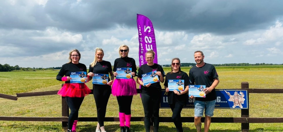 Melanie Batchelor, Nick Marsh, Sophie Beales, Lynne Dean, Rebecca Bowman and Leanne Brooks holding their completed skydiving certificated in Norwich airfield