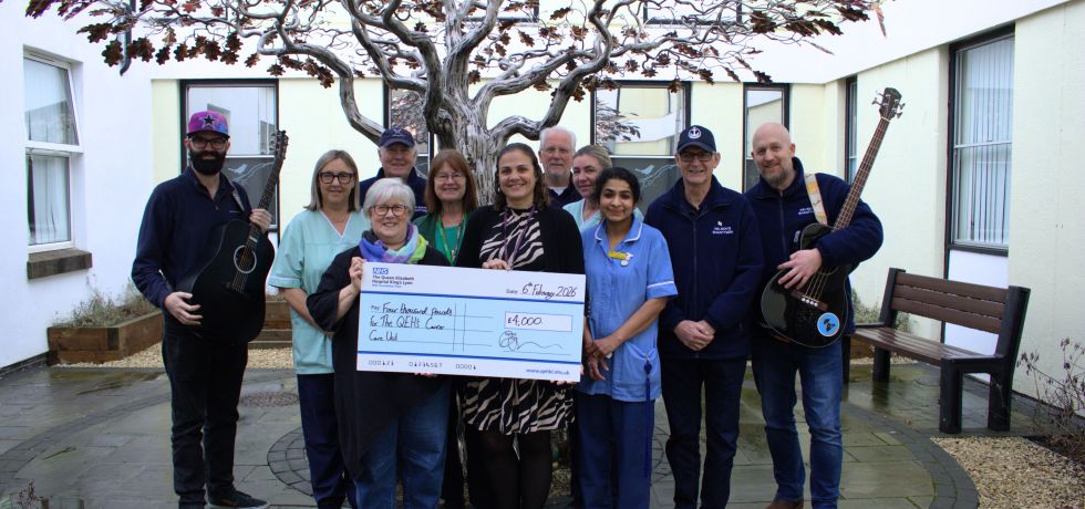 Nelson’s Shanty Men holding guitars and a giant novelty cheque with nursing staff around