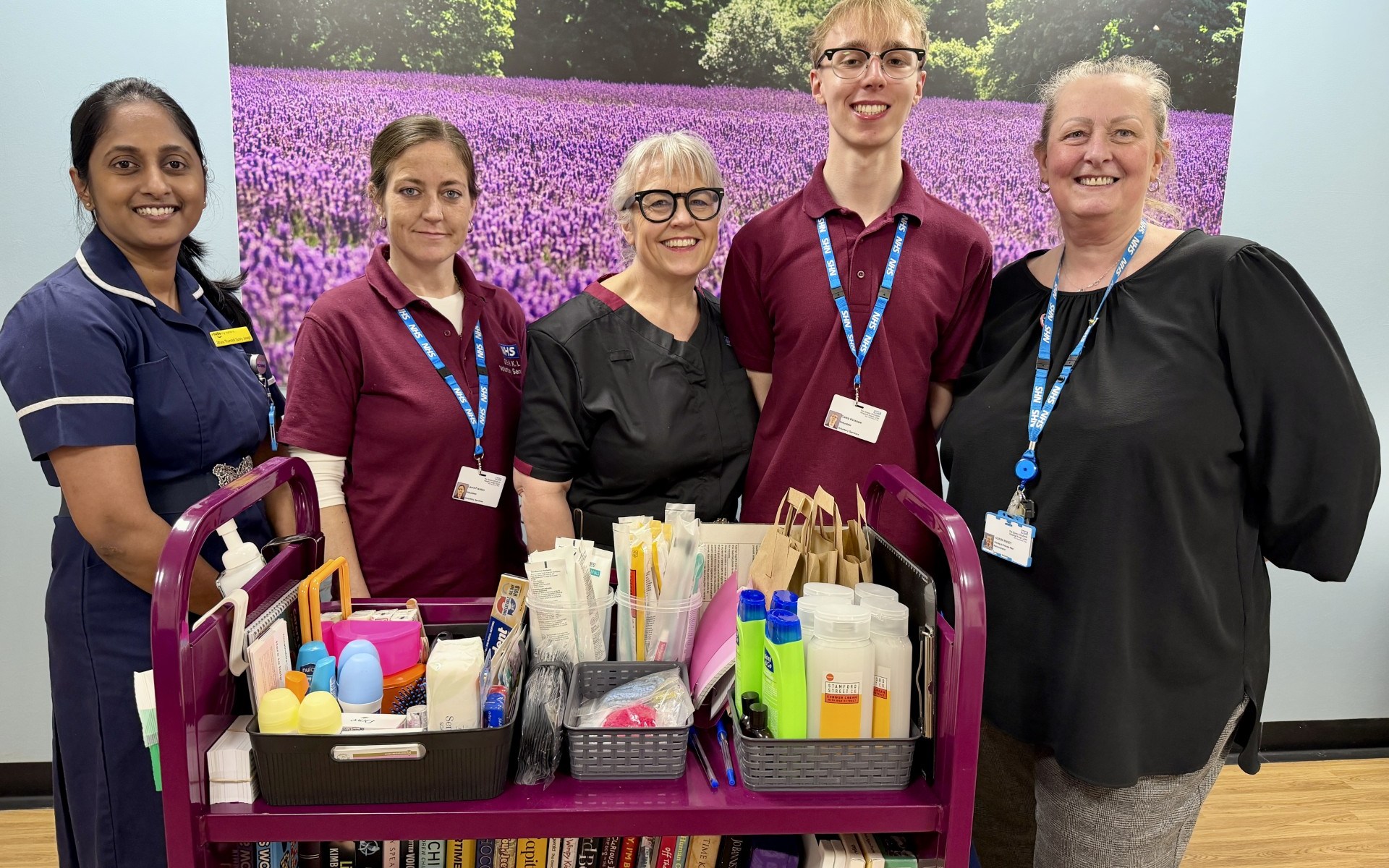 Sithara Thundathil Sunny Joseph, volunteer Laura, Interim Chief Nurse Dawn Collins, volunteer Caleb and Alison Paget standing in front of the comfort trolley,