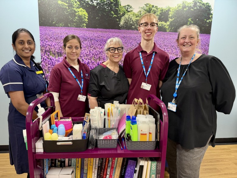 Sithara Thundathil Sunny Joseph, volunteer Laura, Interim Chief Nurse Dawn Collins, volunteer Caleb and Alison Paget standing in front of the comfort trolley,