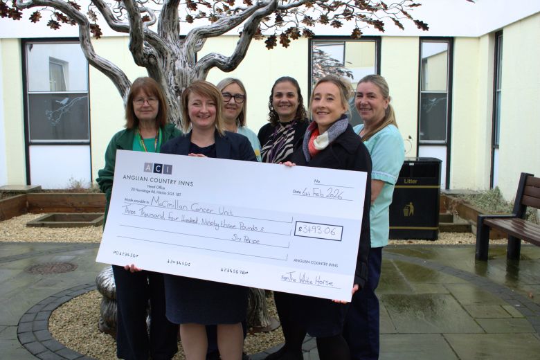 The White Horse represents holding a giant novelty cheque with nurse staff stood around