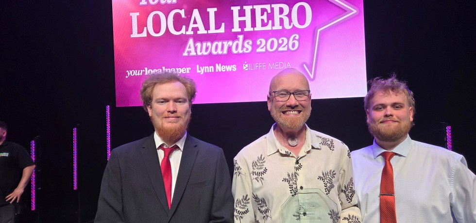 Chris Harrison with his sons on stage, Chris holding his glass award.