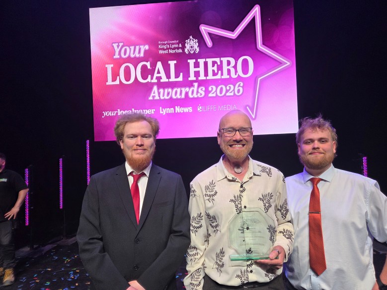 Chris Harrison with his sons on stage, Chris holding his glass award.