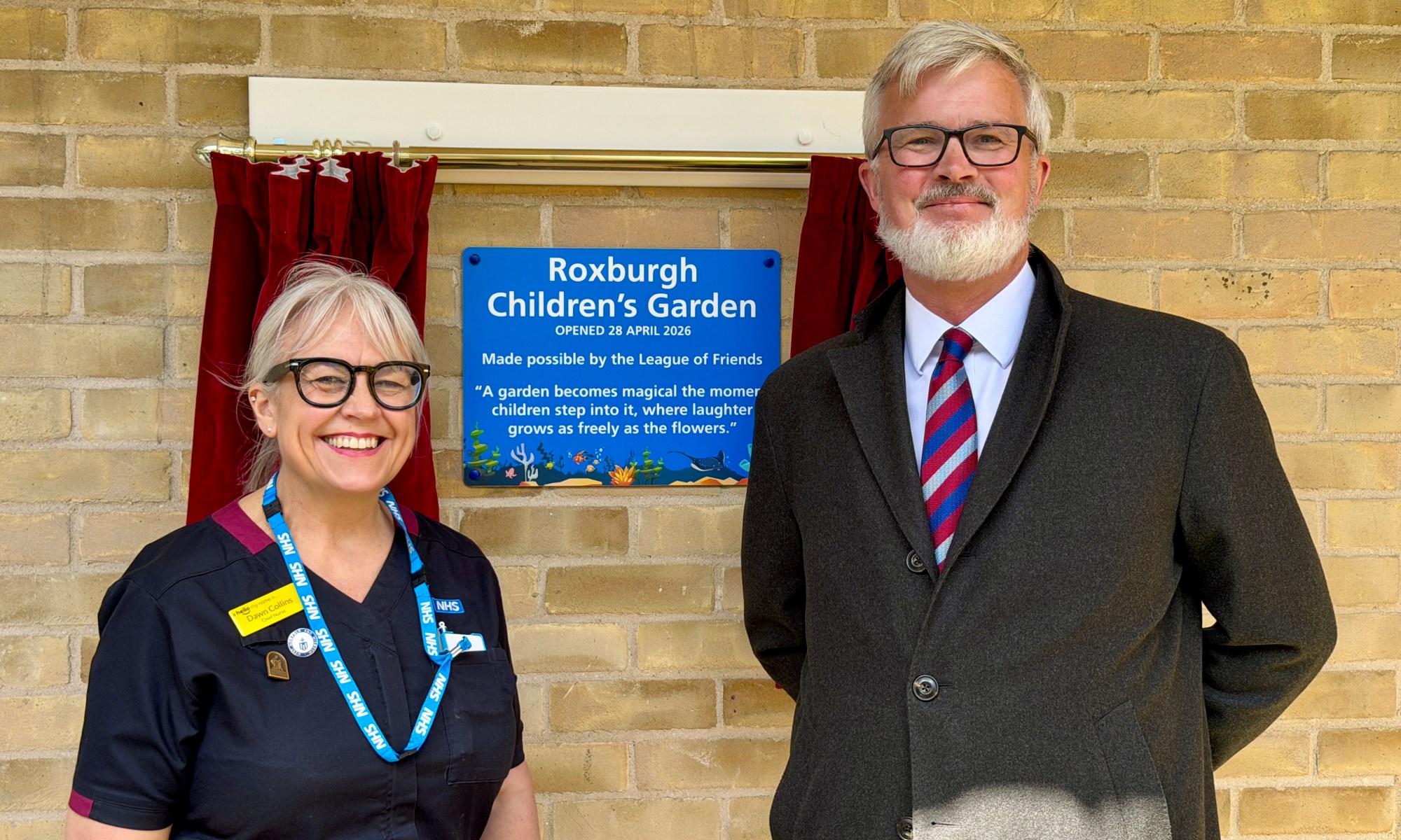 Dawn Collins and Alistair Roxburgh standing outside the newly revealed plaque.