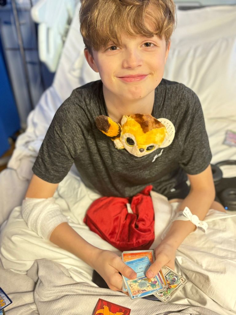 A child patient on a hospital bed with a teddy