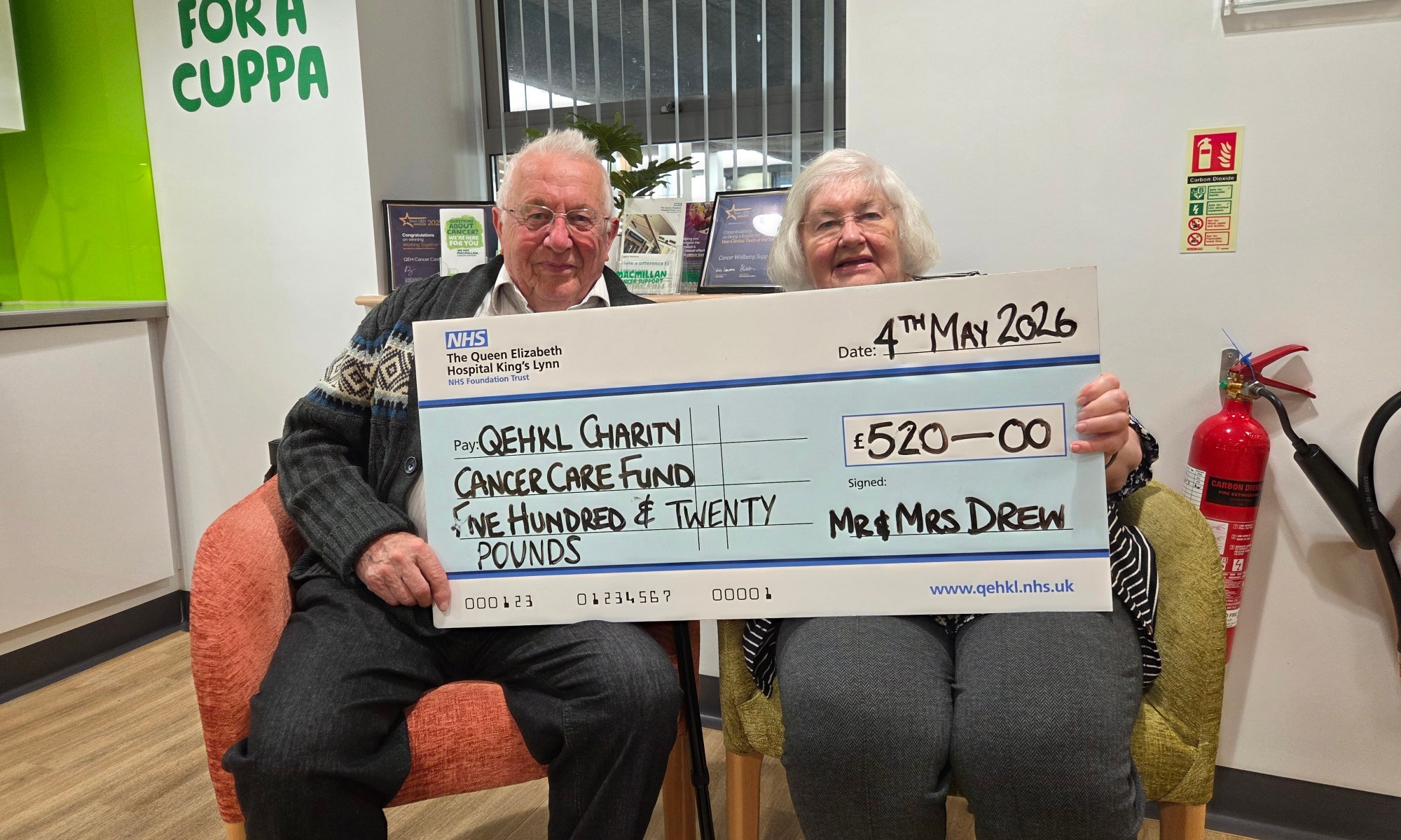 A photo of David and Caroline Drew holding a giant novelty cheque worth £520 for the Queen Elizabeth Hospital King's Lynn's Cancer Care Fund