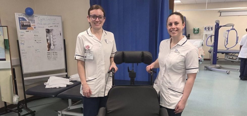 A photo of two nurses stood next to the specialist wheelchair