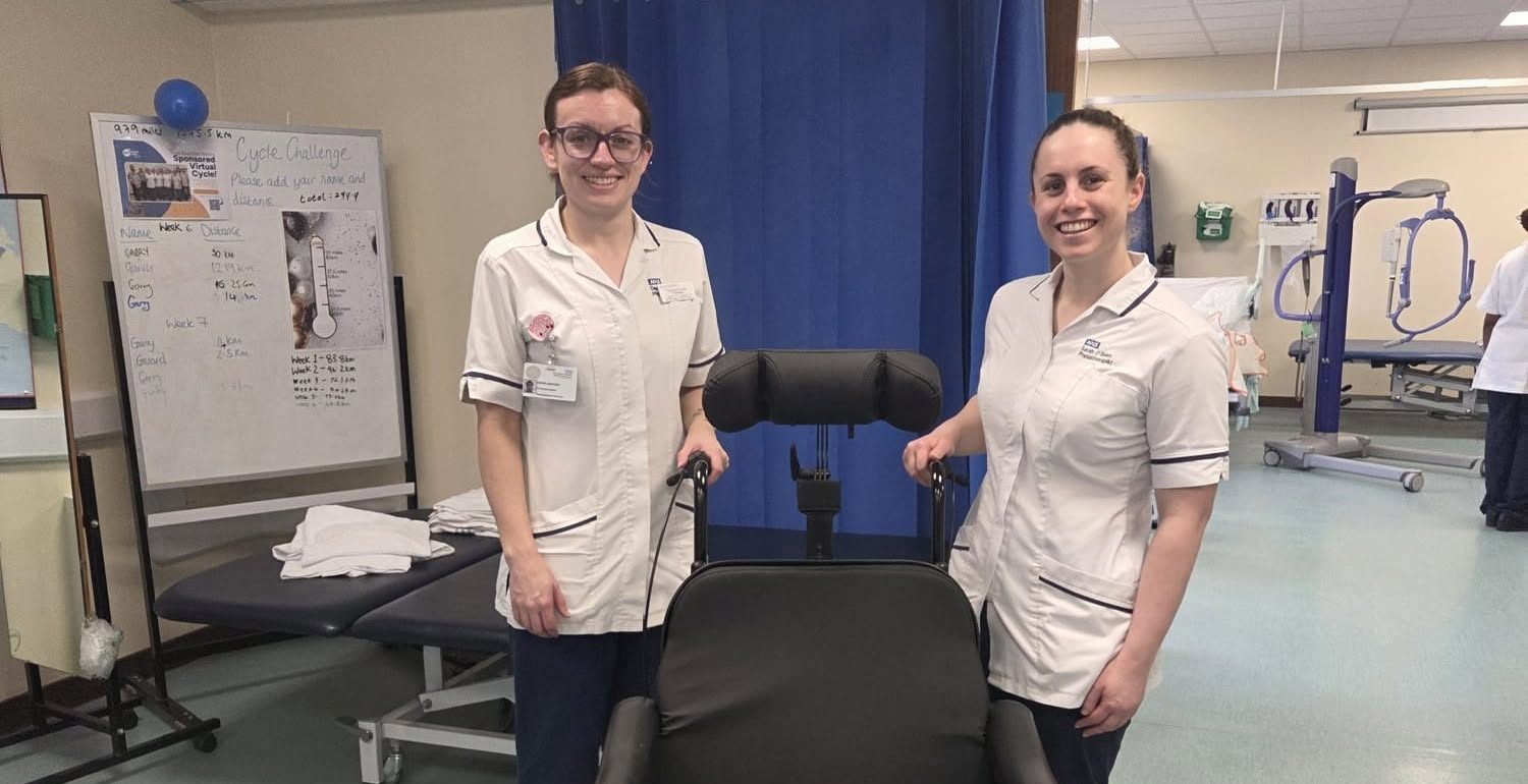 A photo of two nurses stood next to the specialist wheelchair