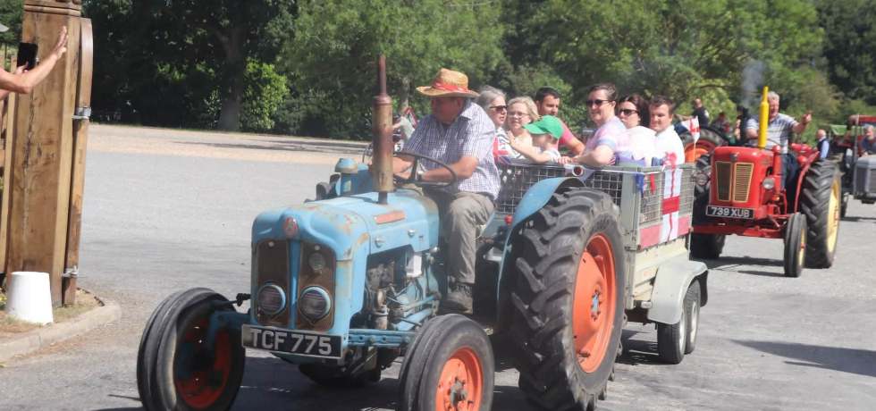 A photo of a row of tractors driving by