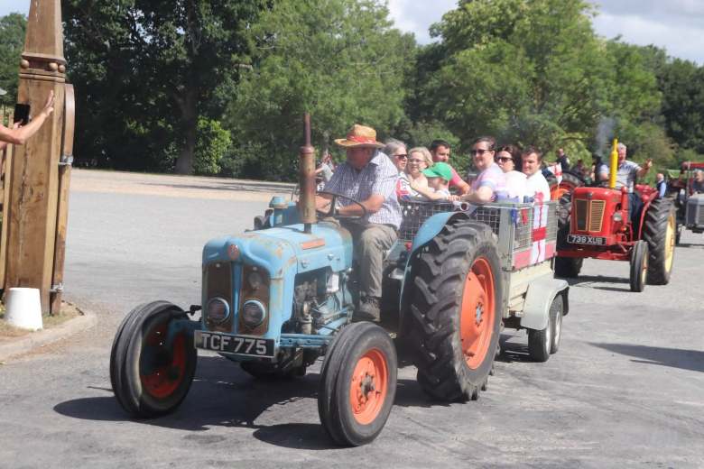 A photo of a row of tractors driving by