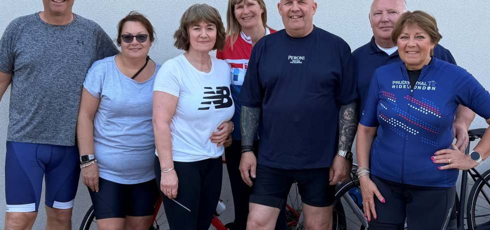 A photo of people stood in cycling gear next to a row of bikes. Included in the photo is Robert Melton, Alison Melton, Julie Follen, Nick Anderson, Kim Anderson, Robbie Maher and Mandy Maher.