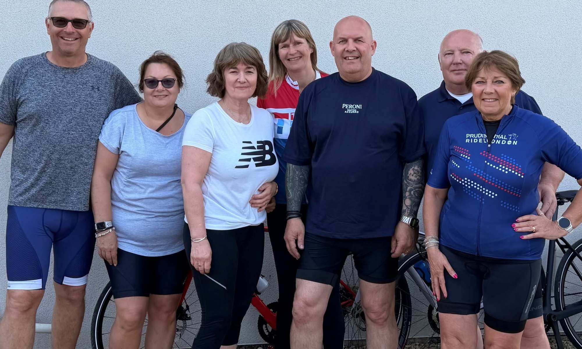 A photo of people stood in cycling gear next to a row of bikes. Included in the photo is Robert Melton, Alison Melton, Julie Follen, Nick Anderson, Kim Anderson, Robbie Maher and Mandy Maher.